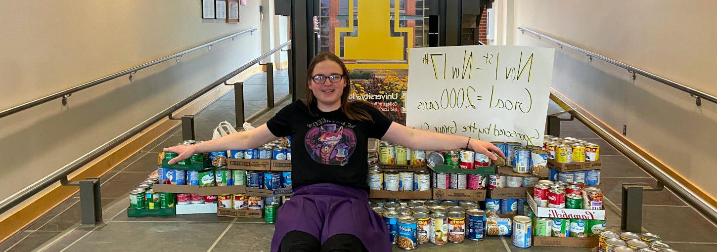 365滚球官网的学生佐伊·埃文斯把她为捐赠购买的罐头食品堆在一起.